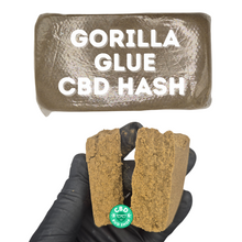 Load image into Gallery viewer, Close-up of Gorilla Glue CBD Hash showing crumbly sticky texture and golden-brown resin